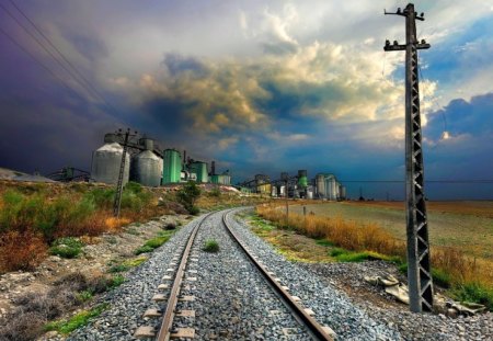 tracks by an abandoned factory - electric pole, tracks, factory, clouds