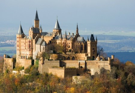 Castle - blue, window, grass, mountain, roof, land, towers, sky, castle, clouds, trees, brick, tan, architecture, daylight, nature, green, day