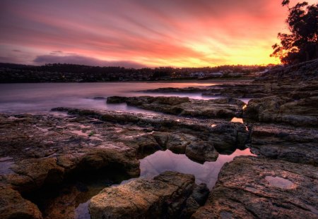 sunset on a coastal town - town, rocks, coast, bay, sunset