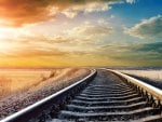 colorful sky over long train tracks