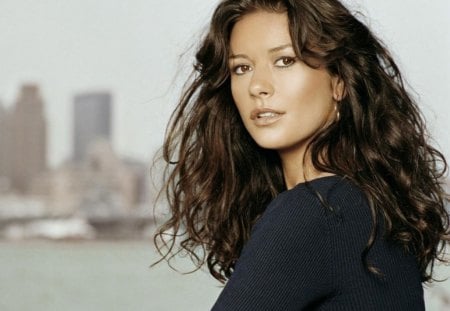 Catherine Zeta-Jones - female, black dress, pretty eyes, brunette, actress, long curly hair