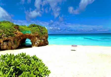 Rocky forms - beach, sky, tropics, greenery, forms, rocks, umbrella, clouds, emerald, sands, ocean, summer, tropical, shore, bushes, nature, shape, beautiful, stones, breeze, sea