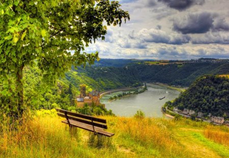 Lovely view - lakeshore, nice, sky, riverbank, greenery, bench, castles, view, river, clouds, tree, high, grass, boat, branches, mountain, summer, shore, lovely, nature, village, beautiful, island