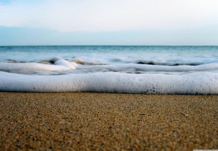 macro photo of brazomar beach spain - waves, sand, foam, beach