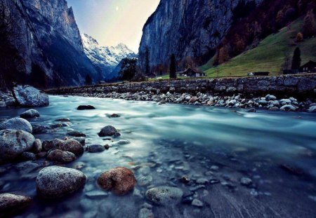 Swiss flow - nice, cottage, sky, slope, riverbank, stream, rocks, reflection, river, cliffs, swiss, houses, mountain, hills, flow, summer, shore, peaks, lovely, nature, floating, beautiful, stones, cabin