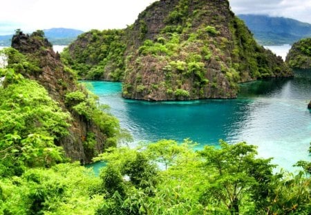 Lovely rock island - summer, rocks, clear, beautiful, emerald, ocean, grass, bright, nature, mountain, greenery, pretty, water, stones, blue, sky, island, nice, clouds, lovely, trees, sea, green