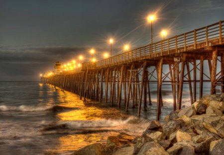 Pier at night - summer, beach, night, reflection, walk, shore, waters, nice, sky, beautiful, sea, lovely, ocean, stones, pier, nature, lights, waves, bridge, rocks