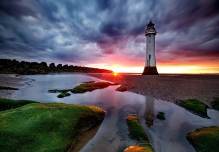 Last sun rays - sundown, amazing, last, grass, sunrise, reflection, shore, sky, sun, clouds, lighthouse, water, tower, sea, stones, glow, nature, sunset, rays