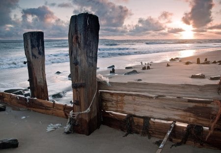 old pylons on a beach - clouds, pylons, beach, sunset, sea, waves