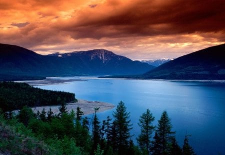 Sunset at the Lake - clouds, trees, water, blue, forest, orange, sunset, nature, green, land, lake, dusk, mountains, day, sky