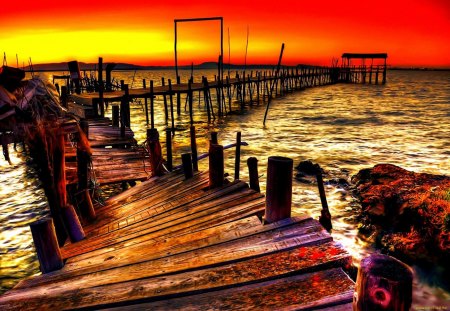 Sunset over the pier - nice, dazzxling, broken, sundown, dock, water, colorful, sunset, shine, pretty, reflection, river, afternoon, morning, rays, ocean, light, wooden, summer, lovely, waves, nature, glow, pier, red, beautiful, sunrise, sea