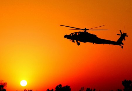 combat helicopter at sunset