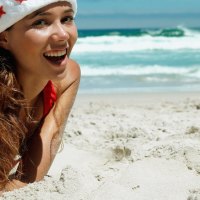 Happy Santa girl on the beach