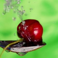 cherry under water in a spoon