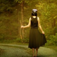 barefoot girl holding in her hand a bow and arrow