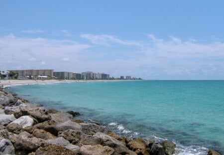 City in the Distance - white, water, green, waves, sand, buildings, rocks