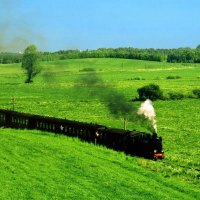 old steam train through grass fields