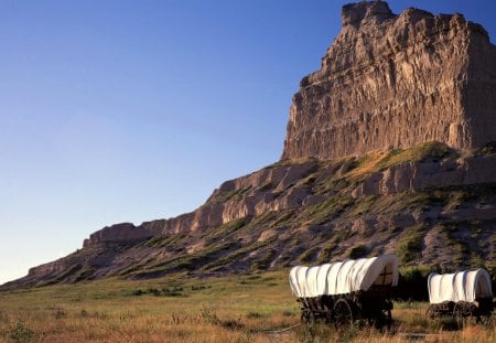 wagons in eagle rock monument nebraska - wagons, monument, cliff, meadow