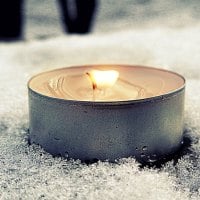 Burning tea candle in the snow