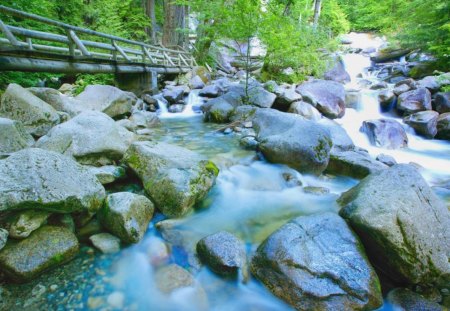 bridge along a fast flowing river - river, trees, flowing, rocks, bridge