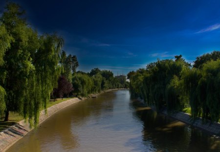 the bega river in serbia - sky, stone banks, trees, river