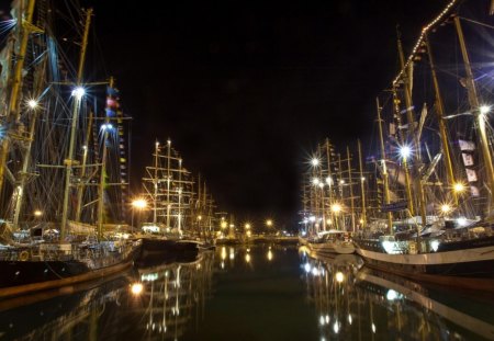 vintage sail ships in a calm harbor at night