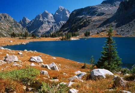 Grand Teton And Lake Solitude  Wyoming - stone, lake, sky, wyoming, landscape, mountain, trees, water, ground, nature, evergreen, rock, brush, landscapes