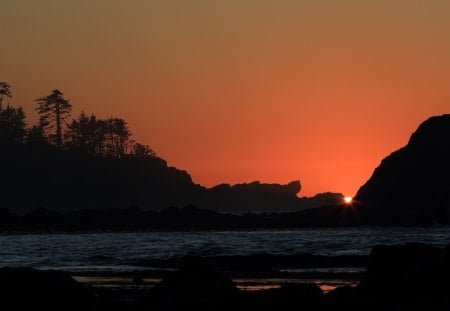 sunset at the silhouetted bay - trees, sunset, beach, silhouette, rocks, bay