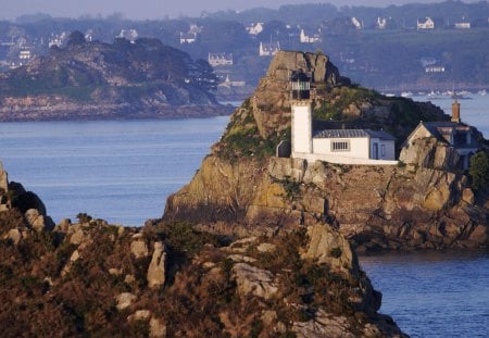 lighthouse tucked in a rocky island - lighthouse, rocks, island, village, bay