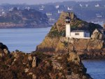 lighthouse tucked in a rocky island