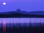 silhouette of a castle under a moon in ireland