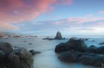 pink clouds over rocky shore