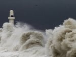 massive waves hitting a lighthouse