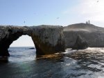 lighthouse above rock arche