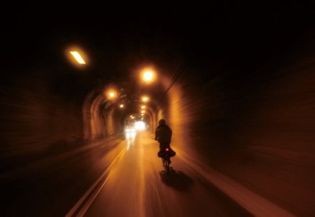 biker riding through a tunnel in taiwan - highway, biker, tunnel, lights