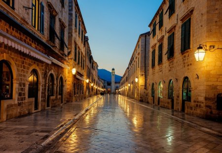 side street after rain at dusk - stores, lights, rain, dusk, stones, side street