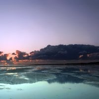 huge beach under stormy skies at sunset