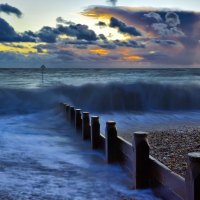 sea waves over breaker at sunset