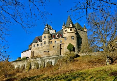 beautiful burresheim castle in germany - hill, blue sky, trees, castle