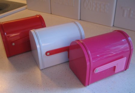 Three mailboxes - white, mailbox, pink, red