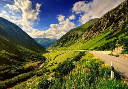 Mountain road - pretty, calm, quiet, hills, summer, grass, mountain, flowers, cliffs, nice, sky, clouds, greenery, beautiful, road, lovely, peaks, slopes, wildflowers, nature, serenity