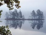 island on a lake reflected in the mist