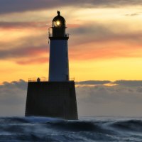 lighthouse on a pier amongst the waves