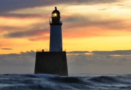 lighthouse on a pier amongst the waves - lighthouse, pier, sunset, sea, waves