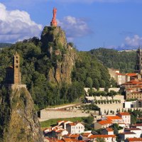 fantastic statue and church on cliffs above a town