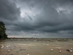 lighthouse on a pier under stormy clouds