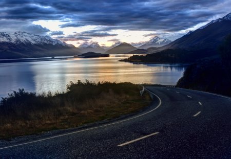 highway around wondrous lake - clouds, highway, sundown, lake, mountains