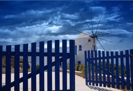 greek windmill behind blue fence - windmill, fence, clouds, blue