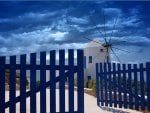 greek windmill behind blue fence