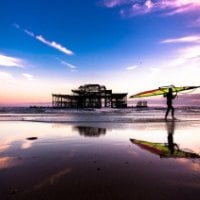 sail surfer by broken pier at sundown